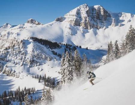 skier in rendezvous bowl overlooking Cody peak